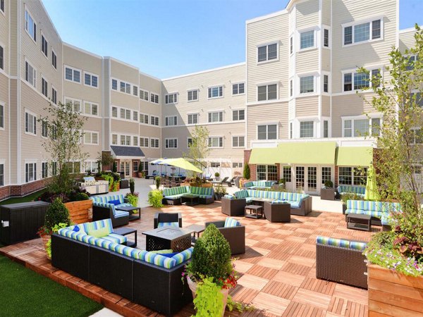 The Hawthorne Apartments: Serene courtyard with lush greenery and seating area
