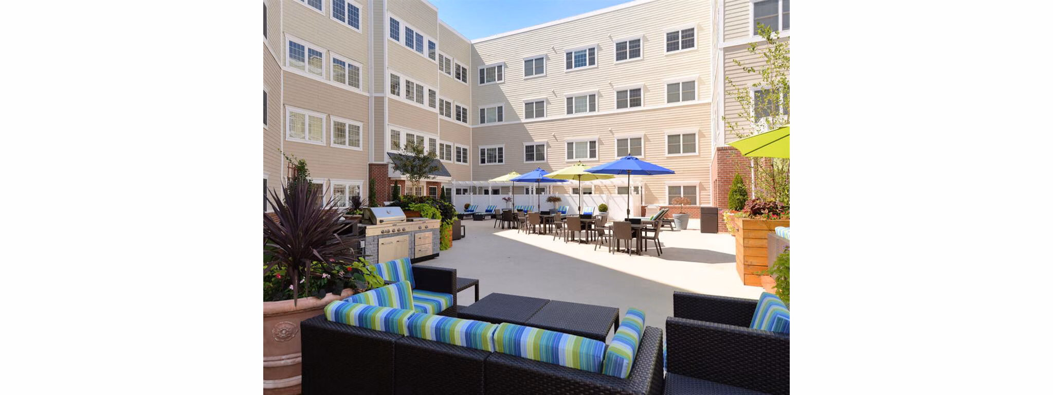 The Hawthorne Apartments: Lush courtyard garden with seating areas, ideal for relaxation in a luxury apartment setting