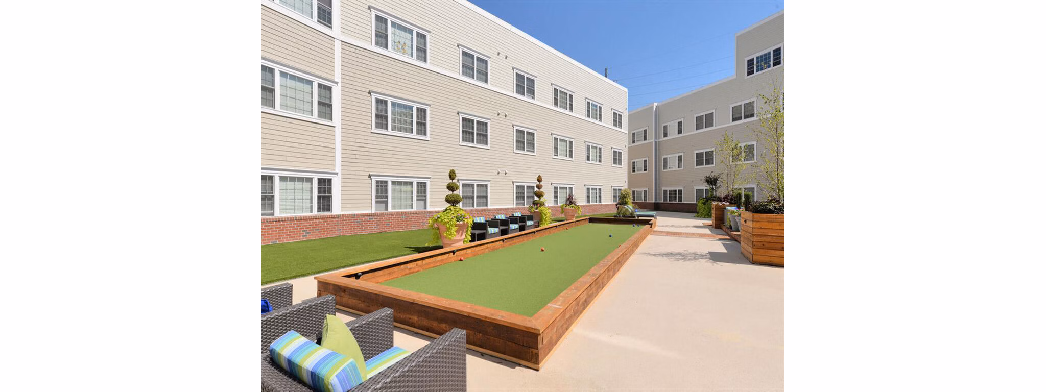 The Hawthorne Apartments: Relaxing courtyard with lush greenery, perfect for outdoor socializing and leisure activities