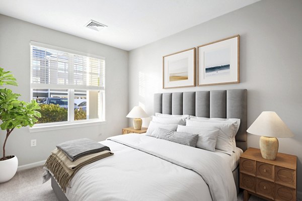 Cozy bedroom with plush bedding and soft lighting at The Prescott at Concord Apartments