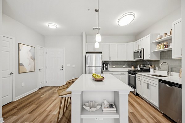 Modern kitchen with stainless steel appliances and granite countertops at The Prescott at Concord Apartments