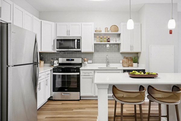 Modern kitchen with granite countertops and stainless steel appliances at The Prescott at Concord Apartments
