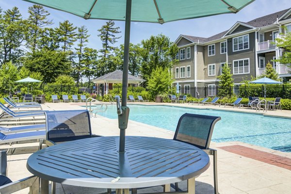 Resort-style pool with sun loungers at The Prescott at Concord Apartments, offering luxury leisure space for residents