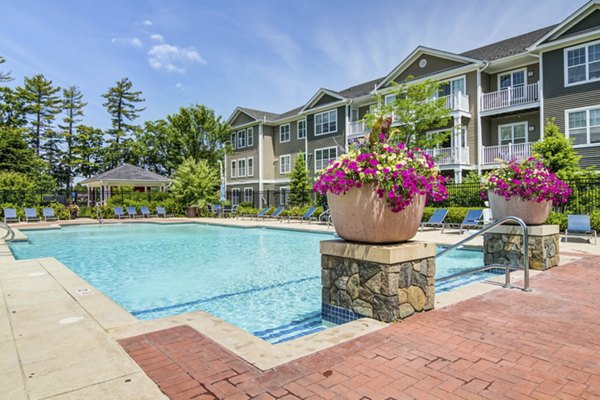 Resort-style pool with loungers at The Prescott at Concord Apartments