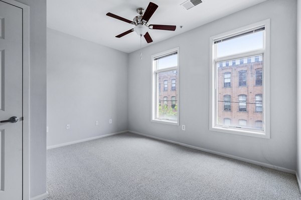 Luxurious bedroom with plush bedding and city views at 1000 Jefferson Street Apartments