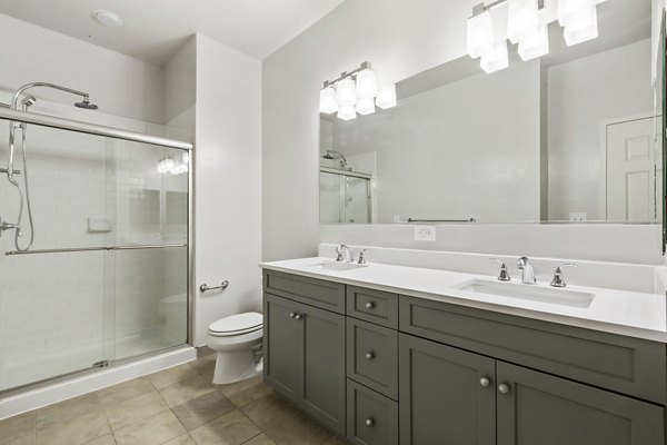 Bathroom featuring marble countertops and modern fixtures in 1000 Jefferson Street Apartments