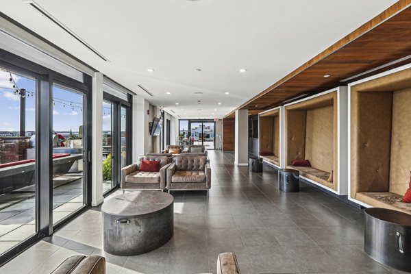 Game room with billiards and lounge area at The Louis Apartments, offering luxury living spaces for residents to enjoy and relax
