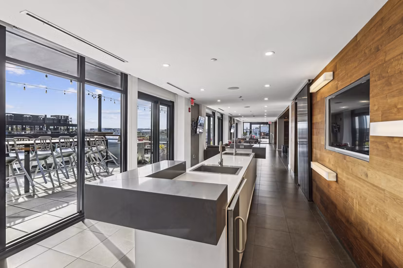 Modern clubhouse with cozy seating and entertainment area at The Louis Apartments, a Greystar luxury living community