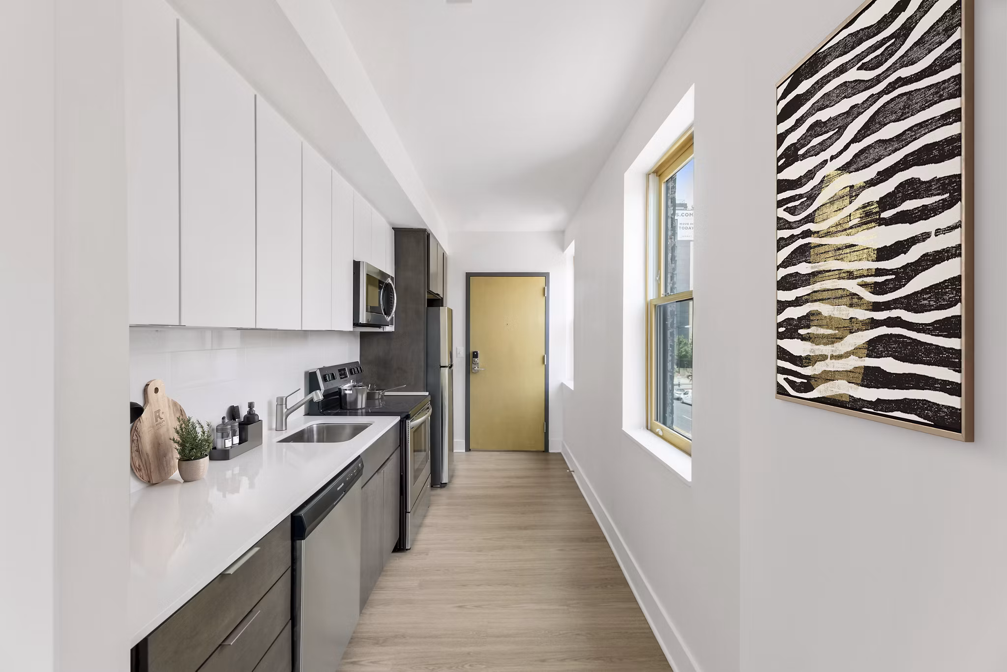 Modern kitchen with stainless steel appliances and granite countertops at Louis at 14th Apartments