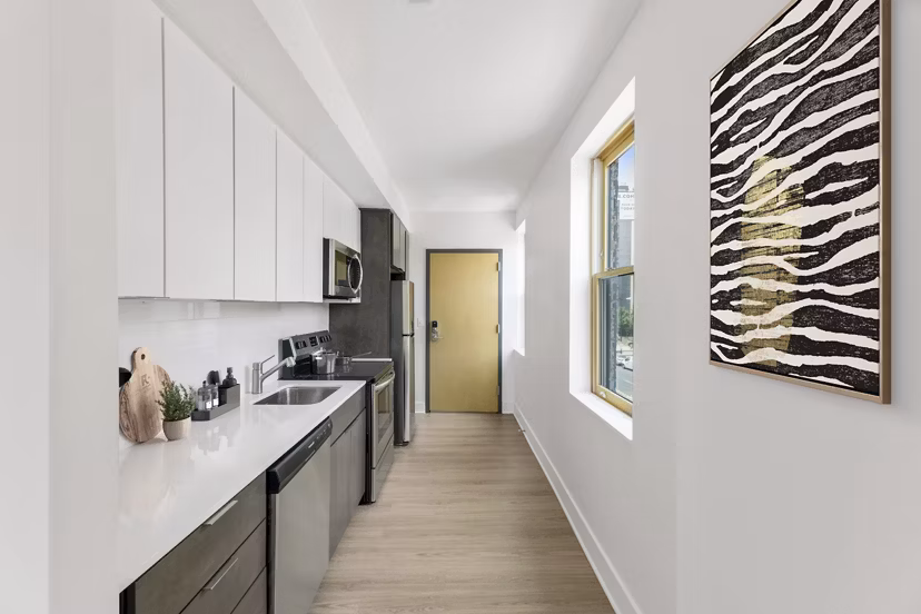 Modern kitchen with stainless steel appliances and granite countertops at Louis at 14th Apartments
