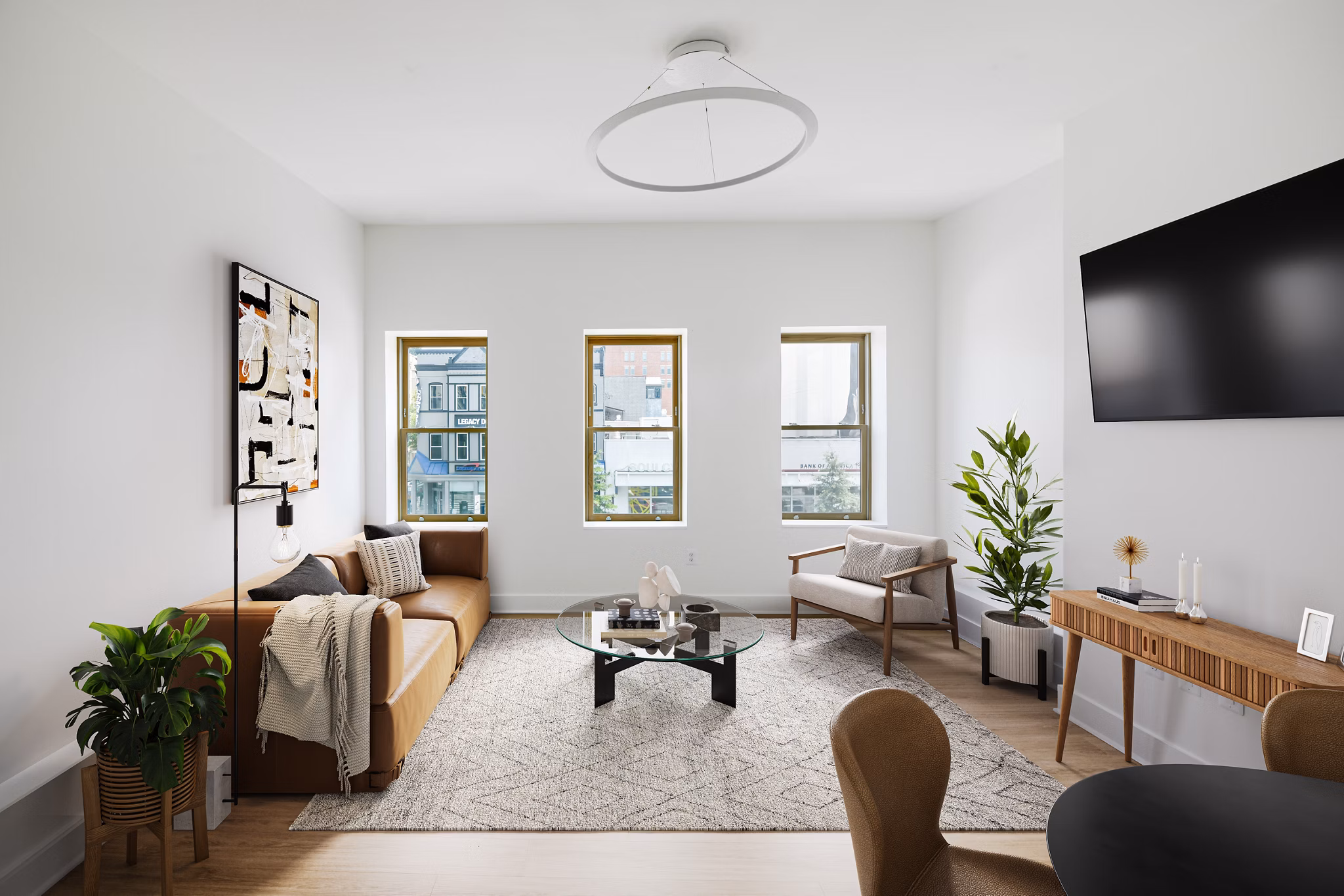 Contemporary living room with sleek design and ample natural light at Louis at 14th Apartments