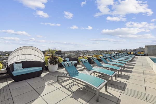 Outdoor pool with sleek lounge area at The Louis Apartments, offering a luxury experience for residents in vibrant city location