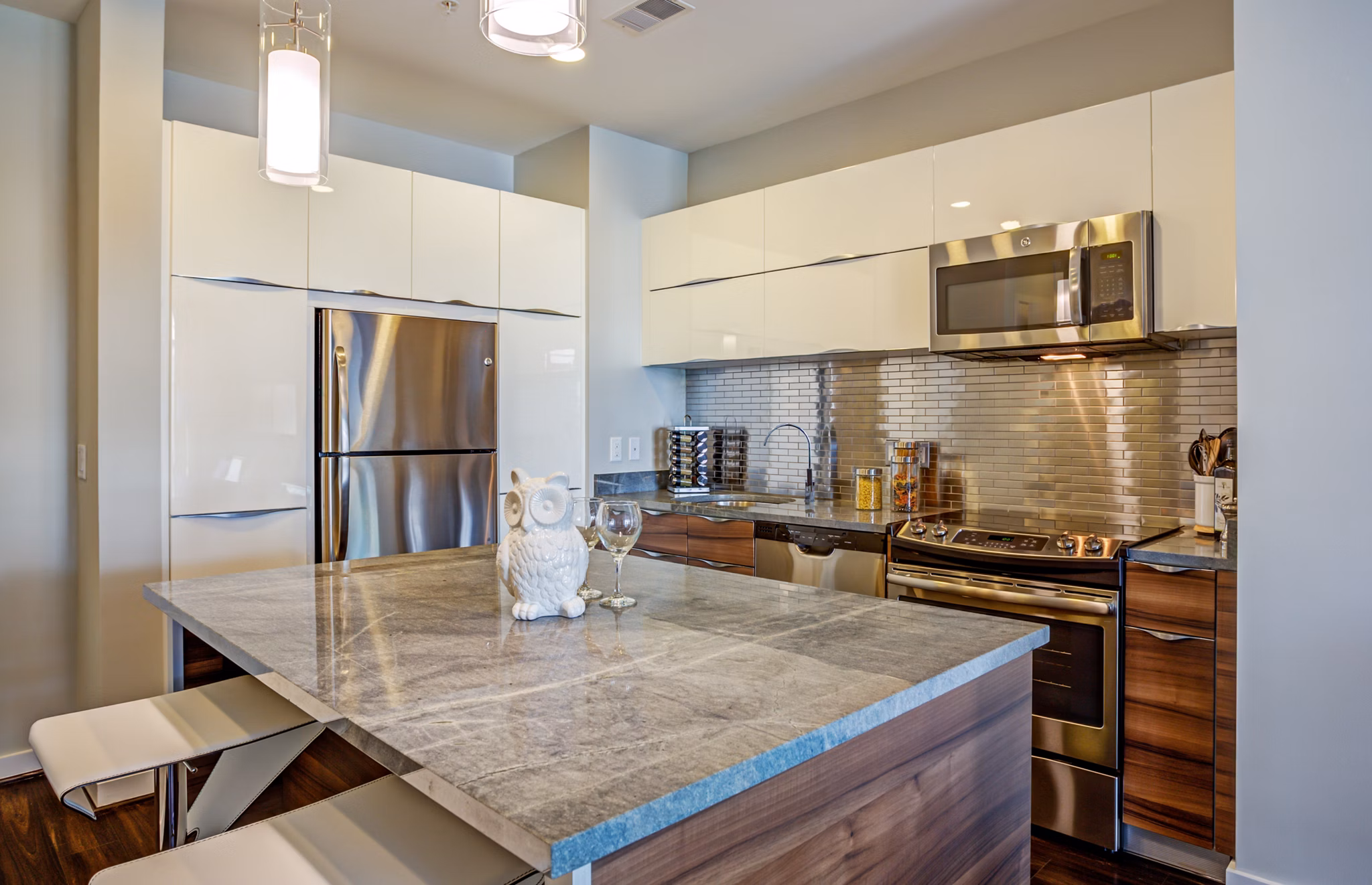 Modern kitchen with sleek appliances and granite countertops in PerSei at Pike & Rose Apartments, Greystar luxury apartments