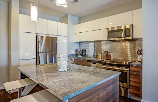 Modern kitchen with sleek appliances and granite countertops in PerSei at Pike & Rose Apartments, Greystar luxury apartments