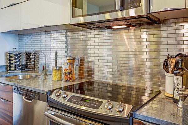 Modern kitchen with stainless steel appliances at PerSei at Pike & Rose Apartments