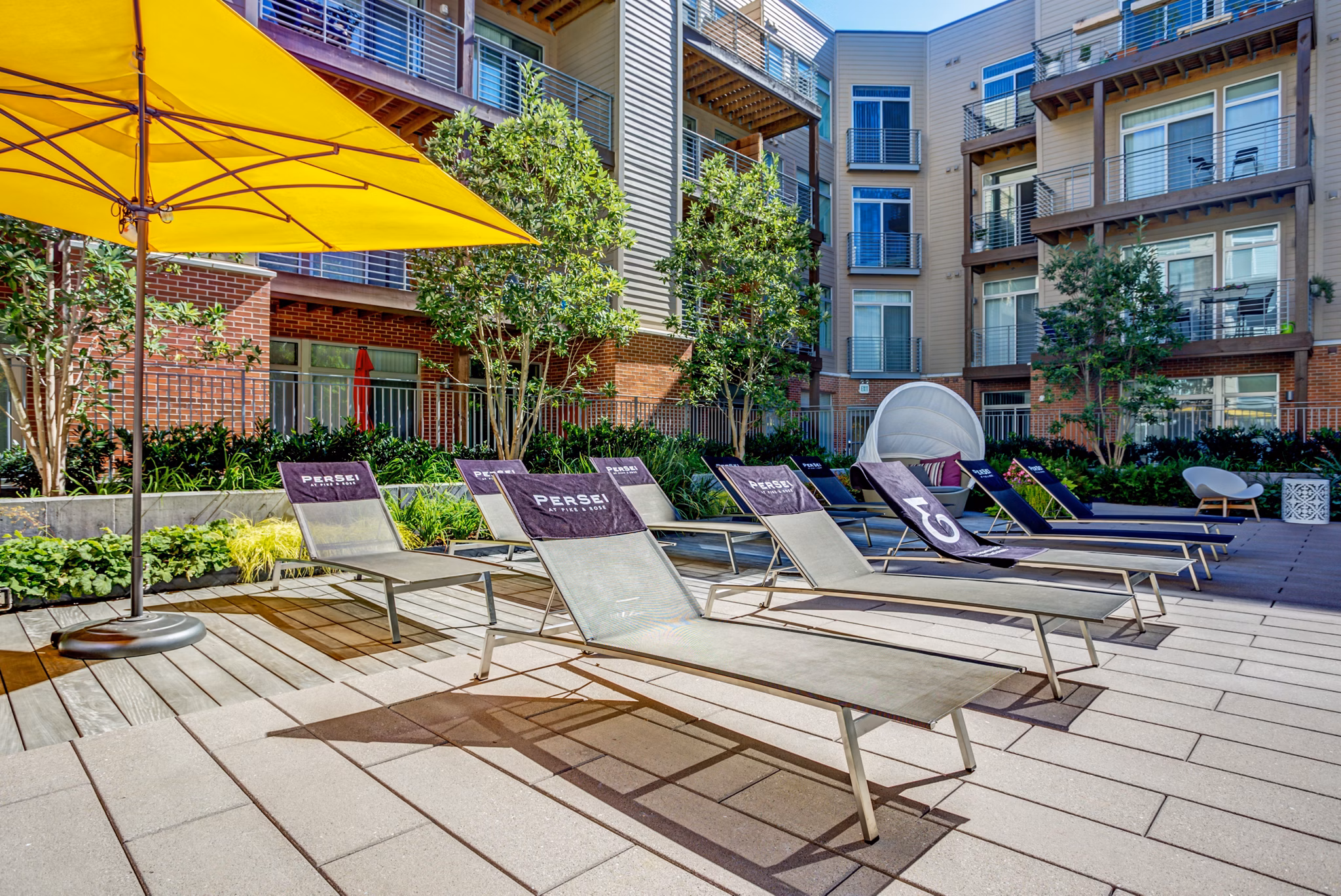 Patio with stylish seating and string lights at PerSei at Pike & Rose Apartments