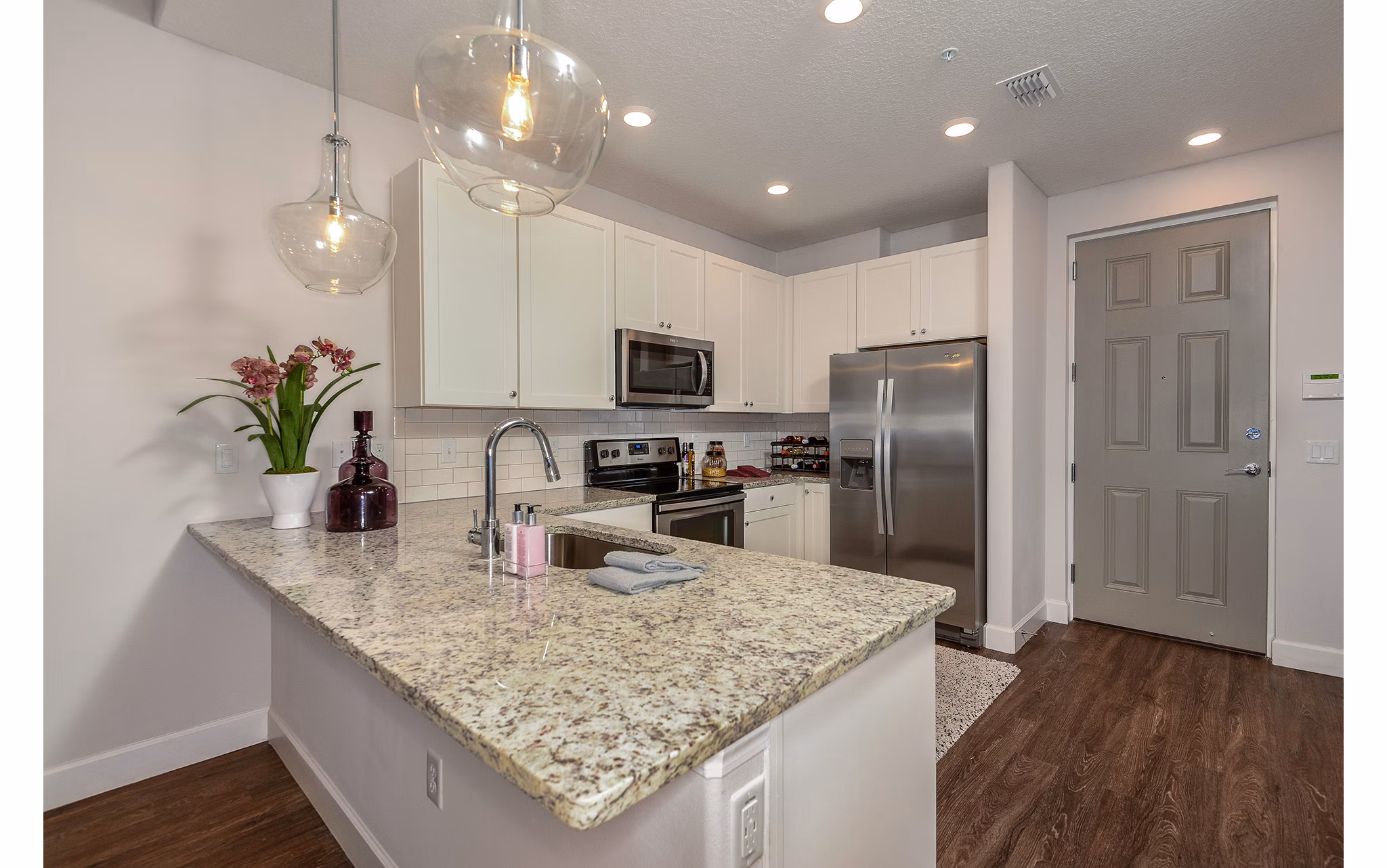 Modern kitchen featuring stainless steel appliances and granite countertops at Urbana Apartments