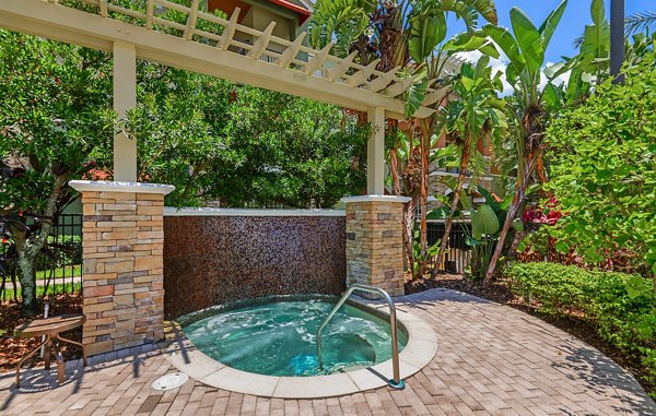 Relaxing hot tub surrounded by lush landscaping at Urbana Apartments