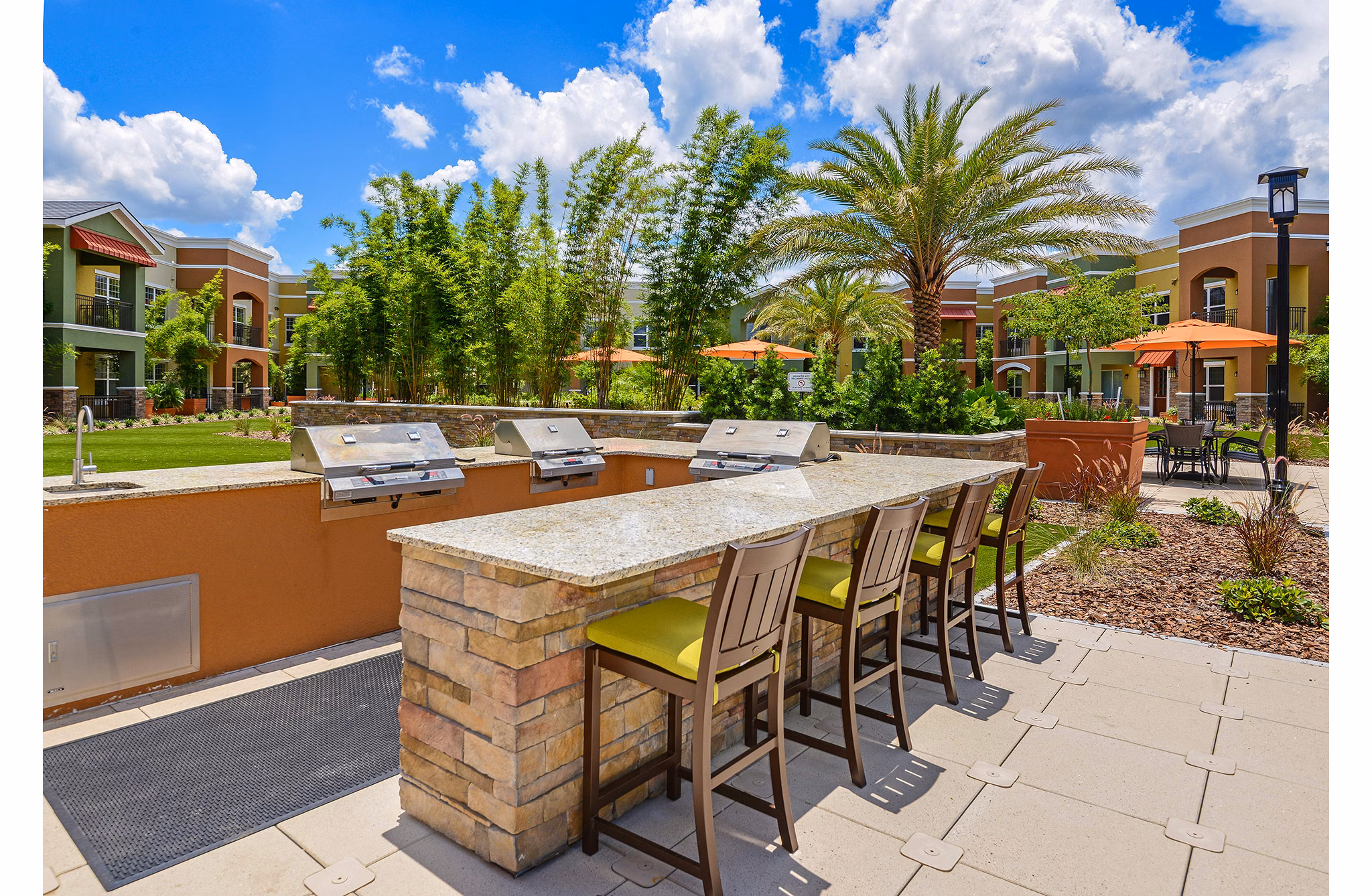 Outdoor grilling area with modern appliances at Urbana Apartments, perfect for social gatherings and relaxation