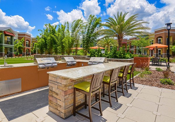 Outdoor grilling area with modern appliances at Urbana Apartments, perfect for social gatherings and relaxation