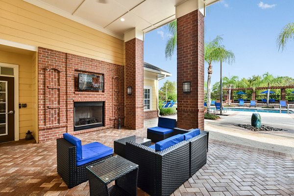 Patio with comfortable seating and lush greenery at Town Center at Lakeside Village Apartments