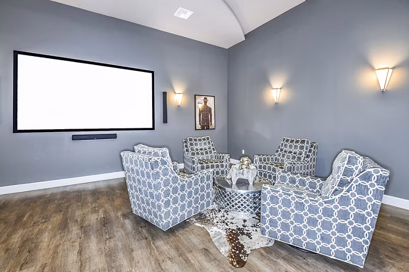 Clubhouse theater with plush seating and large screen at Windermere Cay Apartments, luxury living by Greystar