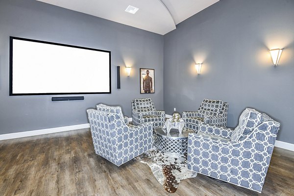 Clubhouse theater with plush seating and large screen at Windermere Cay Apartments, luxury living by Greystar