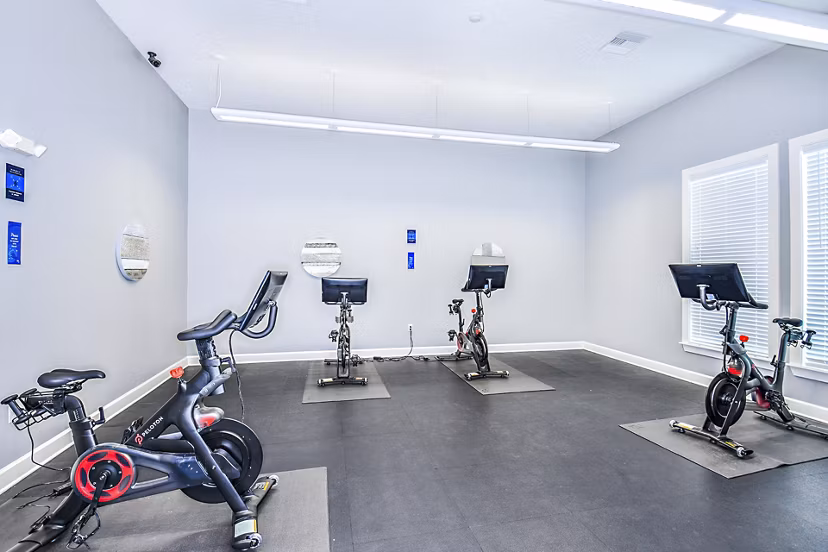 State-of-the-art spin studio with bikes and mirrors at Windermere Cay Apartments, offering luxury amenities and fitness classes