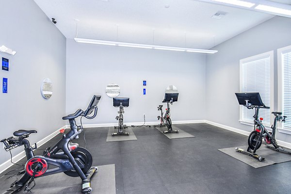 State-of-the-art spin studio with bikes and mirrors at Windermere Cay Apartments, offering luxury amenities and fitness classes