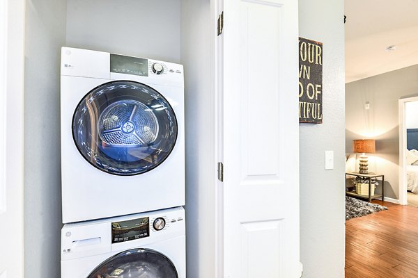 Laundry room with modern machines and ample folding area at Windermere Cay Apartments