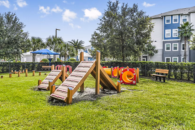 Expansive dog park with lush greenery at Windermere Cay Apartments, ideal for pet-friendly community living