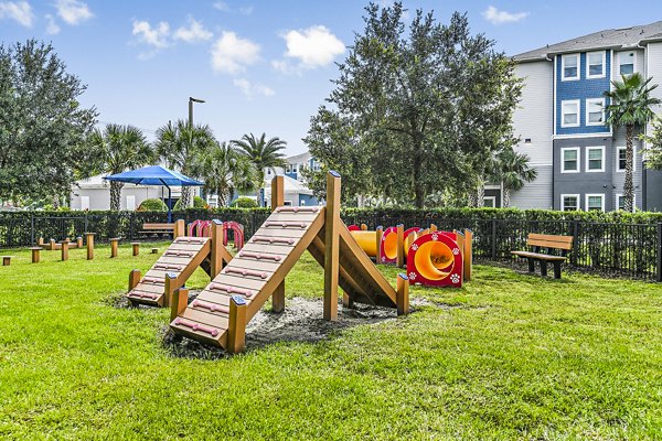 Expansive dog park with lush greenery at Windermere Cay Apartments, ideal for pet-friendly community living
