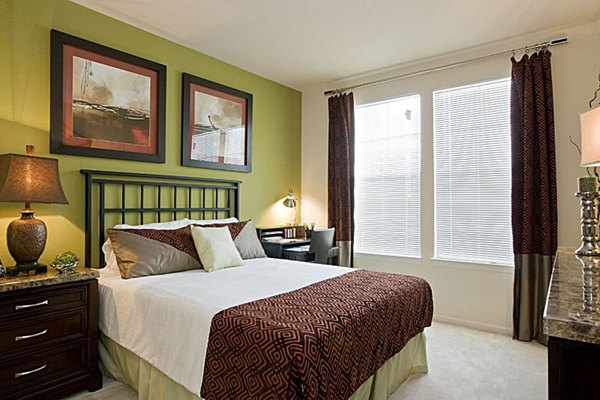 Cozy bedroom with modern furnishings at Aqua at Millenia Apartments, offering luxury living in an upscale Orlando community