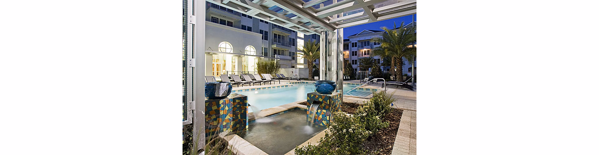 Resort-style pool with palm tree landscaping at Aqua at Millenia Apartments