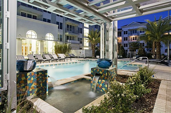Resort-style pool with palm tree landscaping at Aqua at Millenia Apartments