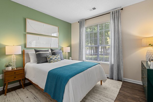 Cozy bedroom with large windows and modern design at The Morgan at Chapel Hill Apartments