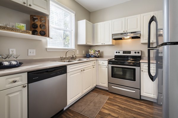 Modern kitchen featuring stainless steel appliances and granite countertops in Wakefield Glen Apartments