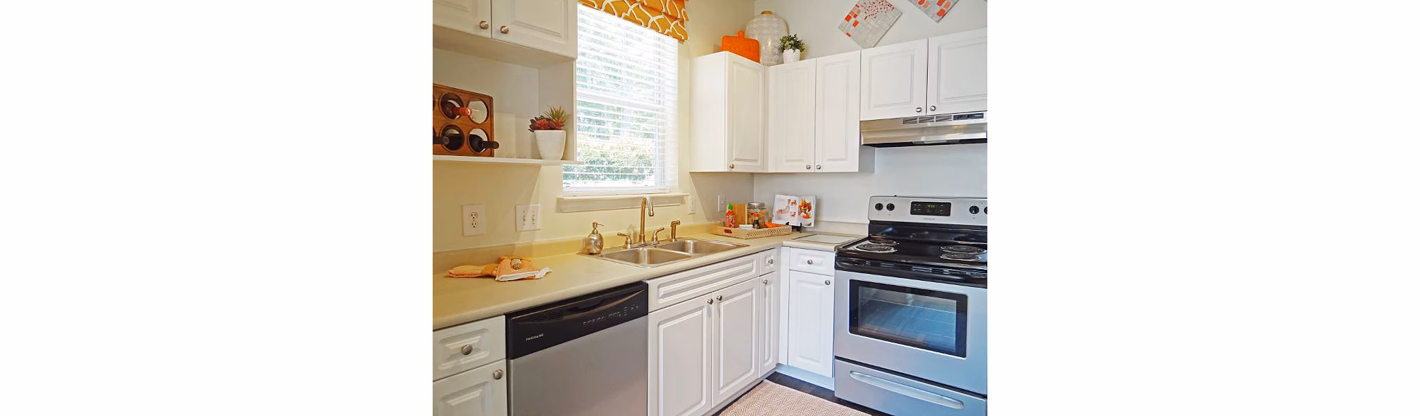 Modern kitchen with white cabinets, stainless steel appliances, and decorative accents in luxury apartments