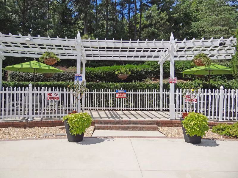 Relaxing outdoor patio at Wakefield Glen Apartments with cozy seating and lush greenery, perfect for enjoying sunny days and cool evenings