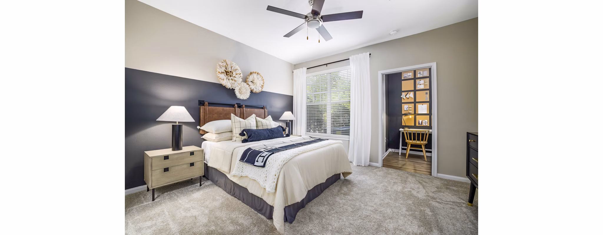 Cozy bedroom with modern decor at Tradition at Stonewater Apartments, featuring a plush bed and ample natural lighting