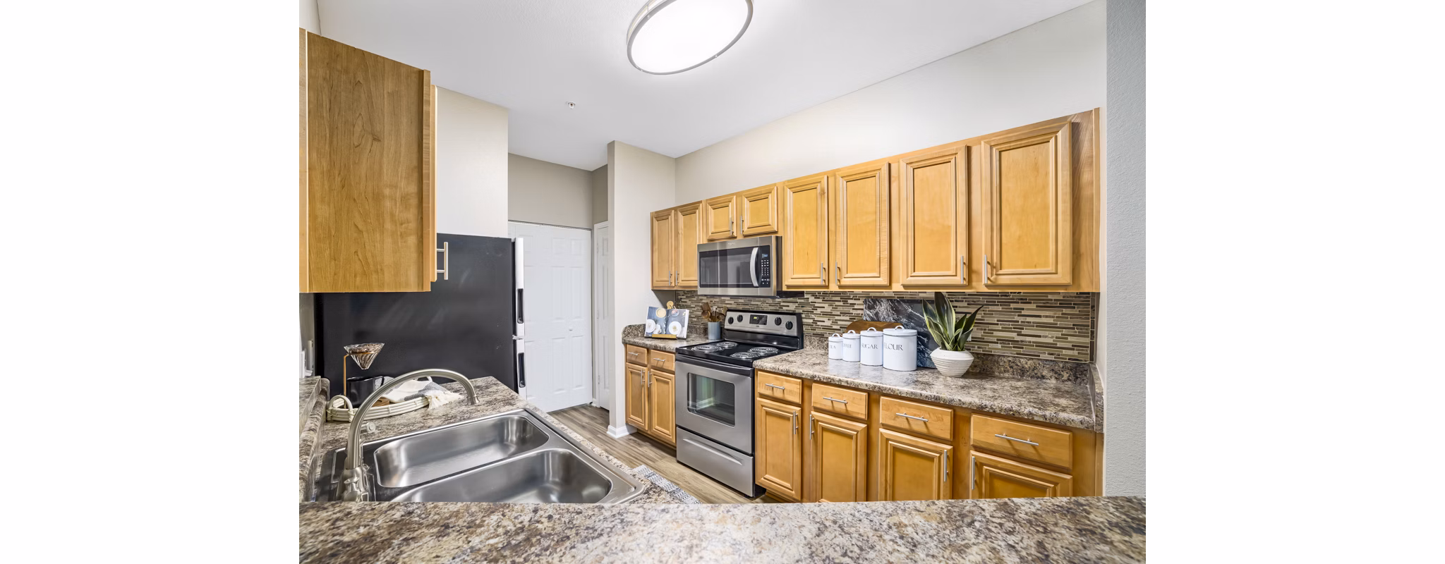 Modern kitchen with stainless steel appliances at Tradition at Stonewater Apartments