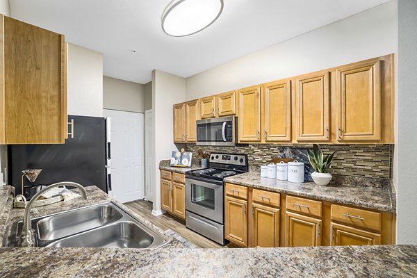 Modern kitchen with stainless steel appliances at Tradition at Stonewater Apartments