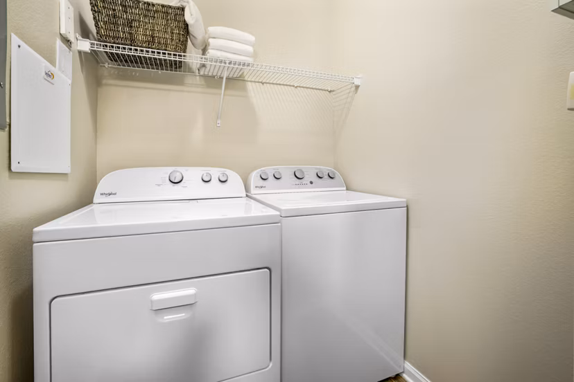 Laundry room with modern appliances at Tradition at Stonewater Apartments, luxury living by Greystar