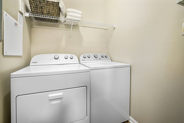 Laundry room with modern appliances at Tradition at Stonewater Apartments, luxury living by Greystar