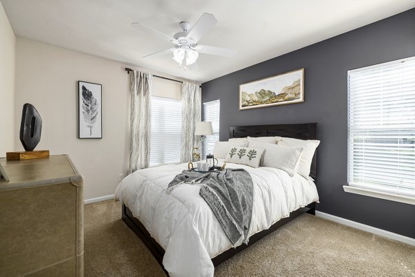 Bedroom with elegant decor and plush bedding at Encore at the Park Apartments, offering luxurious living in a Greystar luxury apartment community