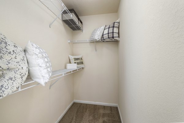 Cozy bedroom with modern decor at Encore at the Park Apartments, featuring ample natural light and plush bedding