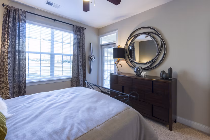 Bedroom with plush bedding and elegant decor at Morgan Reserve Apartments, offering luxury living in a serene environment