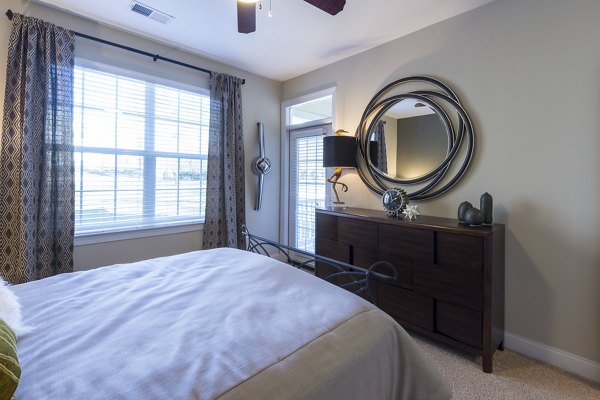 Bedroom with plush bedding and elegant decor at Morgan Reserve Apartments, offering luxury living in a serene environment