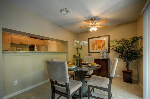 Dining room featuring elegant wooden furniture and large windows in Canyon Woods Apartments