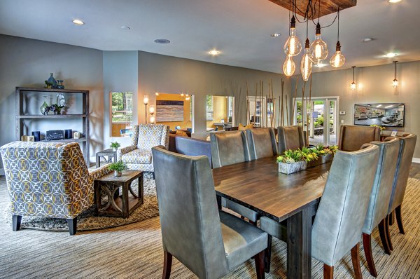 Clubhouse with modern seating and a fireplace at Hampton Greens Apartments